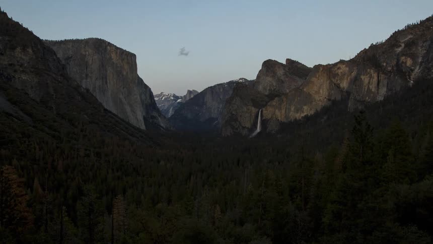 Time lapse from day to night of a distance waterfall in the El Capitan valley