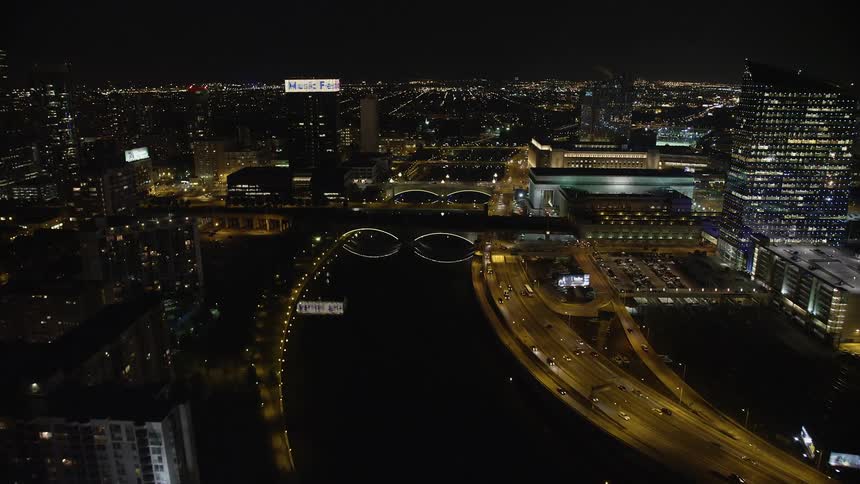 Aerial footage of small bridges spanning the illuminated Schuylkill River in Philadelphia Pennsylvania during a summer night