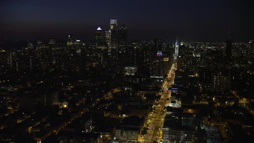 A nighttime aerial view of Downtown Philadelphia skyline and Broad Street leading to City Hall Pennsylvania featuring historical buildings high rises and famous landmarks