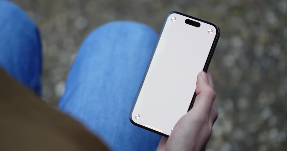 A close up of a persons phone in their hand as they scroll with their thumb