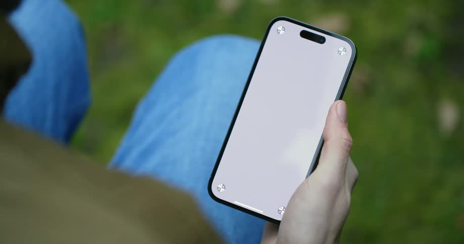 A man scrolls through his phone while sitting outside