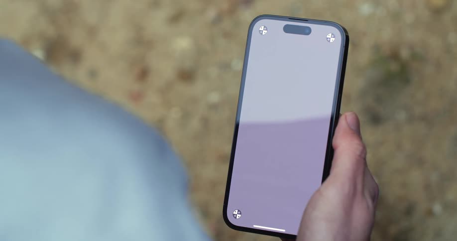 A man scrolls through his phone while outside