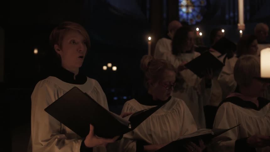 A choir singing in a dark church