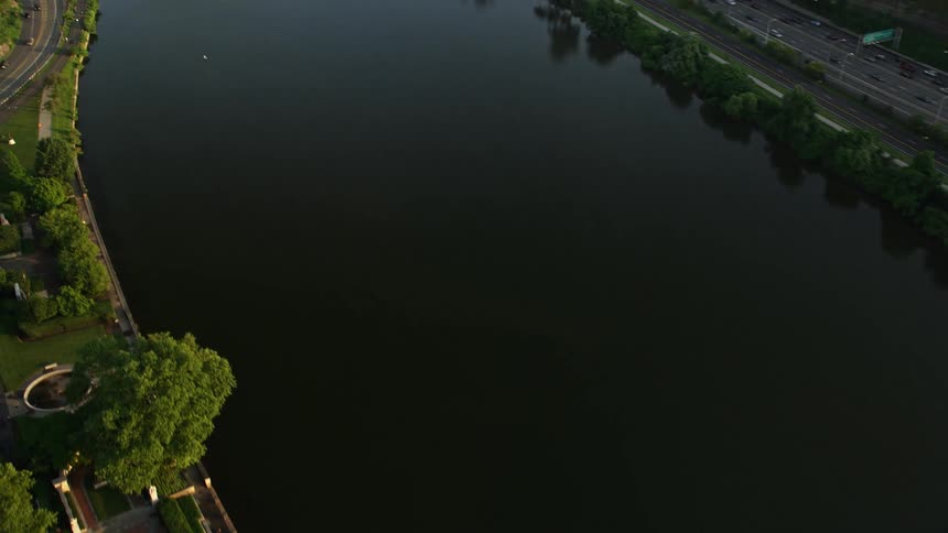 Aerial footage captures the scenic beauty of Philadelphia with landmarks - Boathouse Row Museum of Art City Hall and skyscrapers - on a clear sunset evening while panning across the Schuylkill river