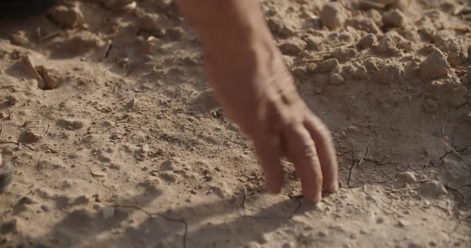 A woman is scratching at the desert sand