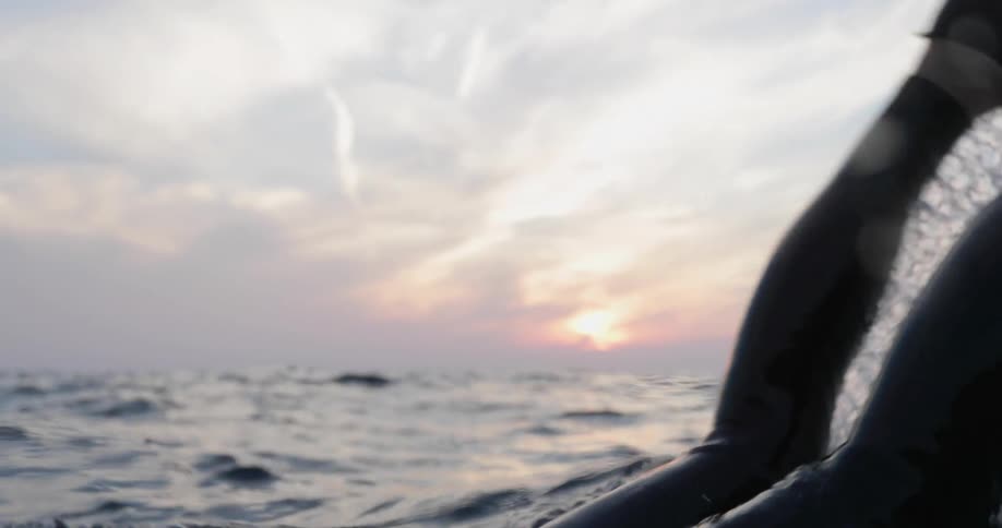A man in the ocean dives under the water