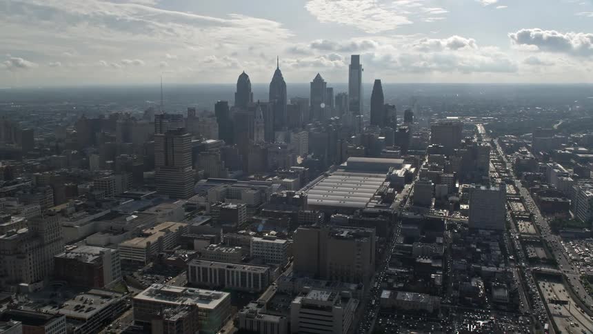Aerial footage captures the approach towards the Pennsylvania Convention Center and skyscrapers in downtown Philadelphia on a cloudy day