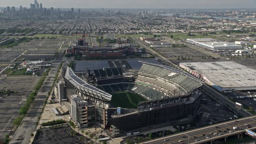 Cars are driving near a stadium in a downtown city
