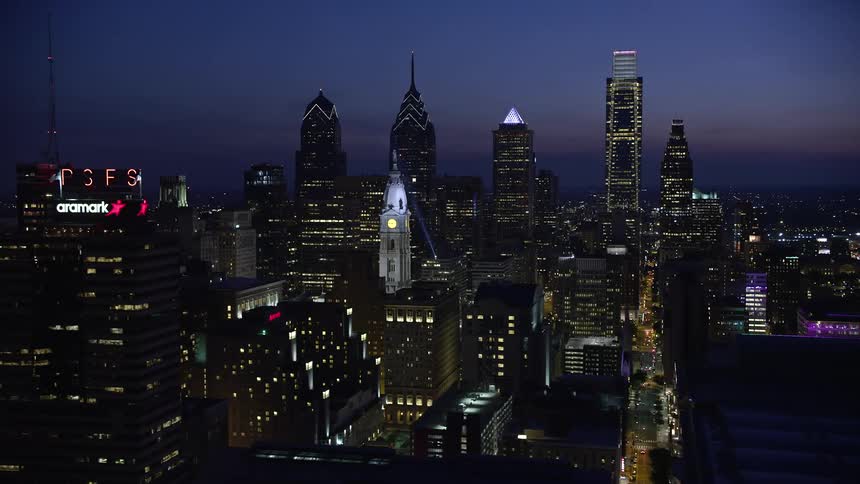 Aerial footage of Downtown Philadelphia skyscrapers including the city hall and Pennsylvania Convention Center at night