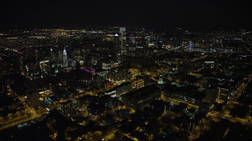 Approaching and orbiting Downtown Philadelphia skyscrapers at night in a clear sky