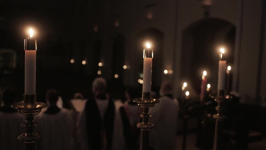 Church candles flickering behind a choir