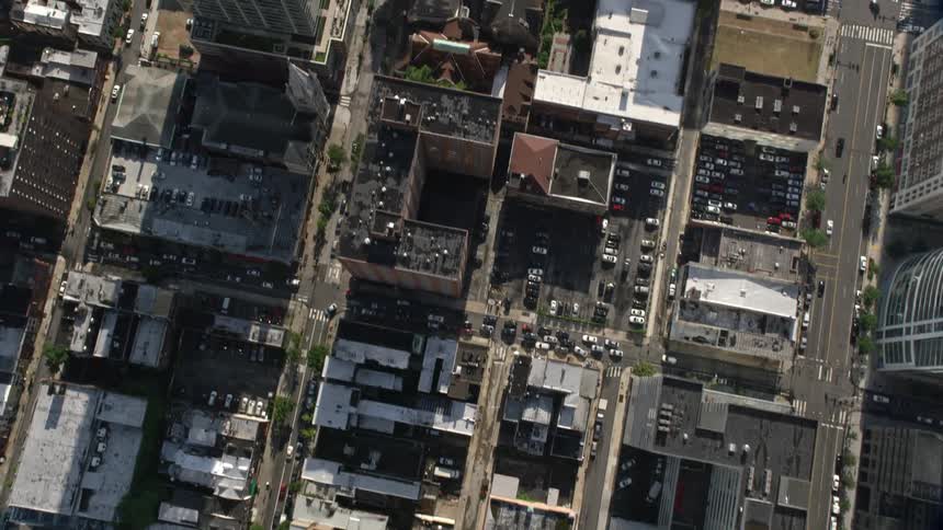 Aerial view of Downtown Philadelphia city streets and buildings during midday with traffic and construction crane in view