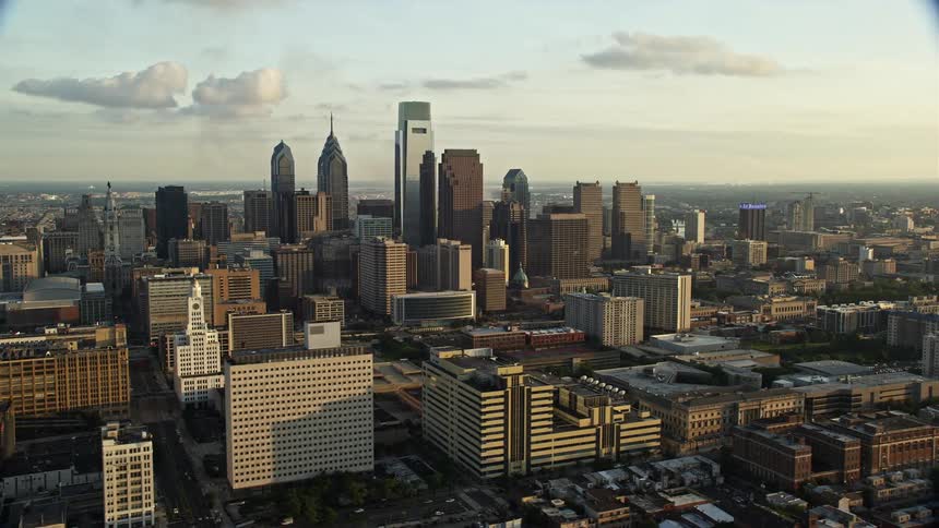 A stunning aerial view of the high-rise buildings and skyscrapers of Downtown Philadelphia during sunset captured in footage