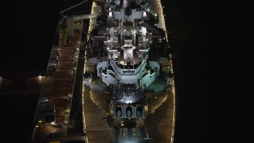 A aerial view of the USS New Jersey a docked navy vessel in Camden New Jersey at night