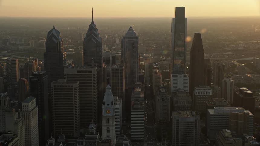 Aerial footage captures Philadelphias downtown at sunset showcasing the government building and iconic skyscrapers