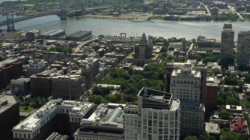 An aerial view of the St James near Independence National Historic Park and Customs House in Downtown Philadelphia Pennsylvania on a sunny day displaying the citys iconic structures neighborhoods and bodies of water during spring or summer