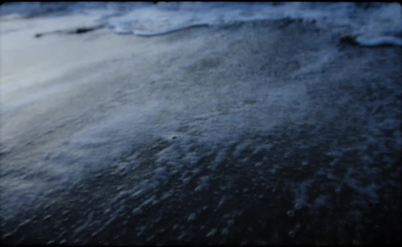 Waves rolling on to the shore as the sun sets