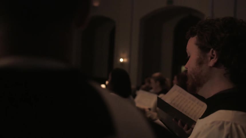 A church choir performs while holding sheet music