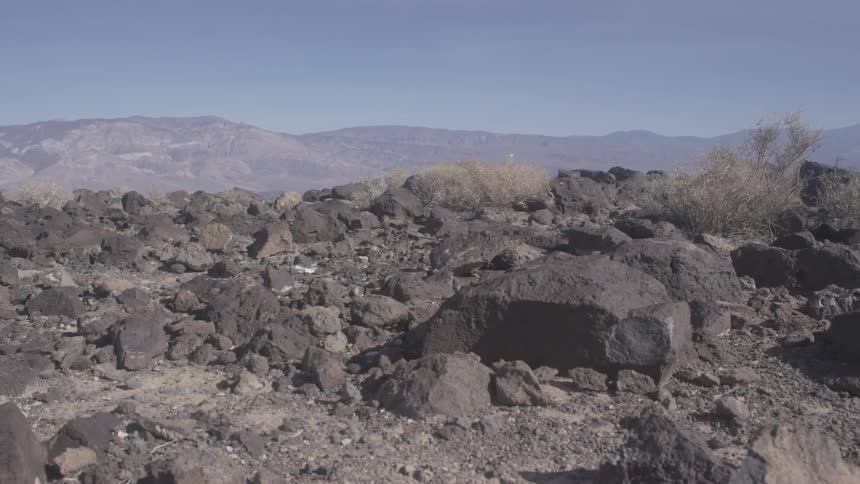 Rocks and boulders strewn across the foothills of a mountain range