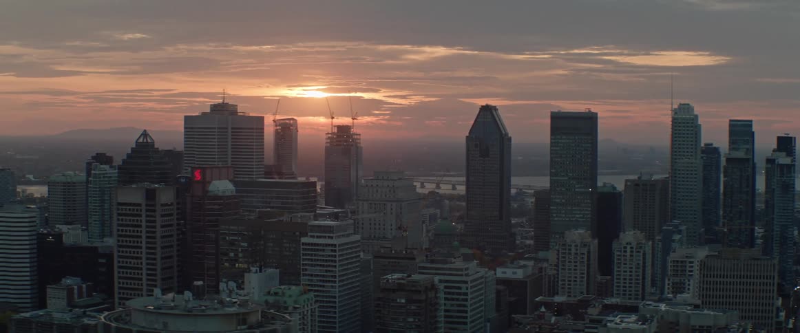 Sunlight peaks through clouds over a city at dusk