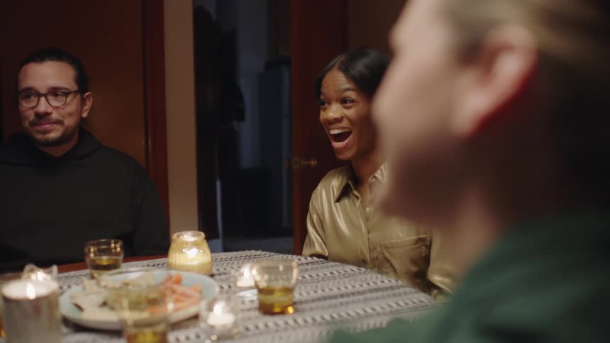 Friends listen during dinner as another friend tells a story
