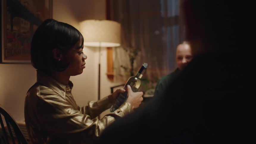 A woman pours wine at a party