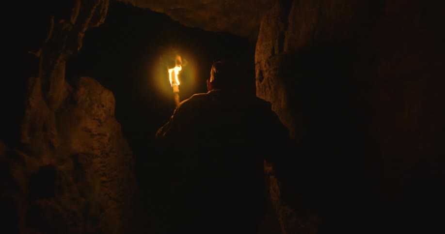 A person is walking through a cave during the night time