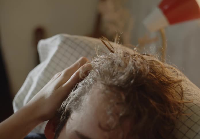 A man is laying own in his bed in the morning time
