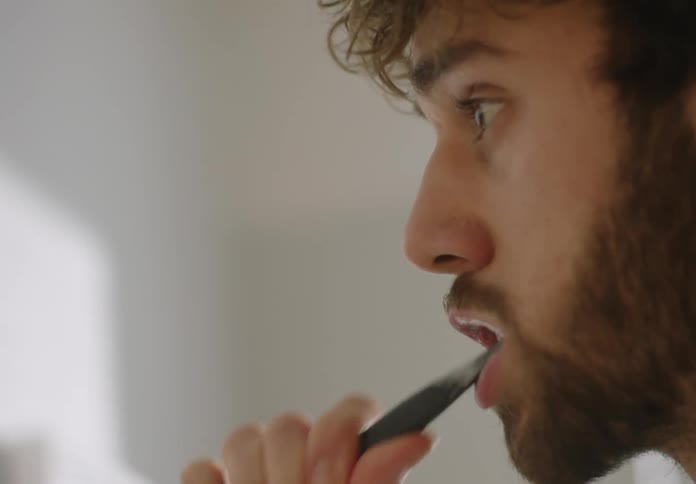 A man is brushing his teeth