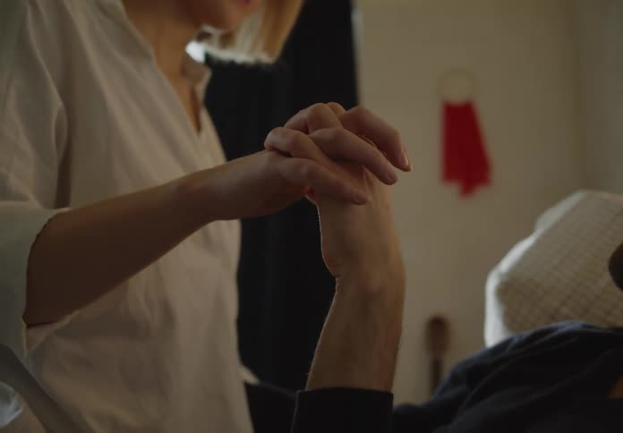 A couple is holding hands indoors in the daytime