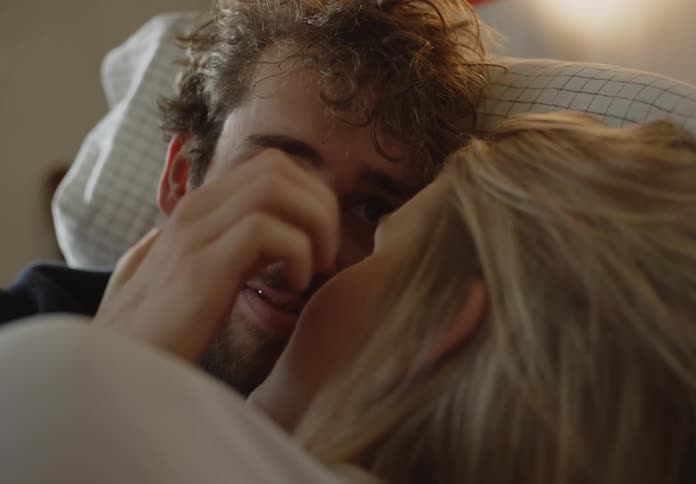 A man and woman cuddling in a bed