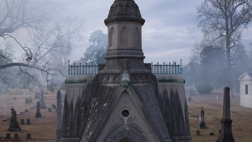 A crypt in a cemetery on a cloudy day