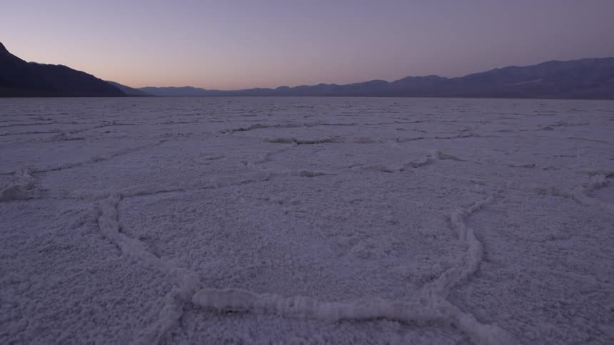 A snow covered mountain pasture at sunset