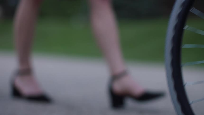 A persons feet in a wheelchair while two other people walk behind them