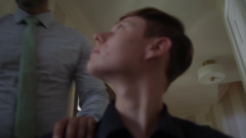 A man maneuvers through a hall while another man walks behind him