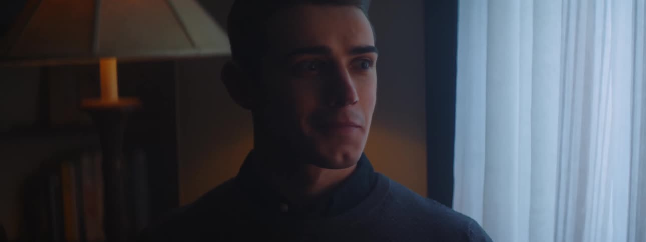 Man sitting shakes his head before smiling and standing