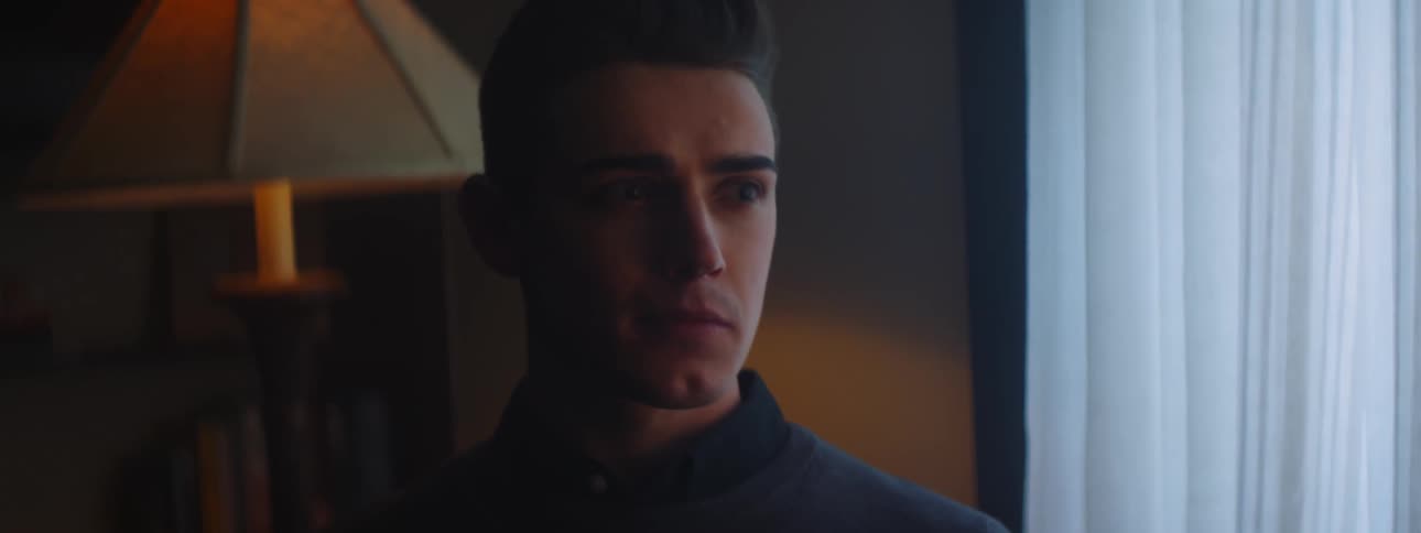 A man smiles wide before standing up from a chair