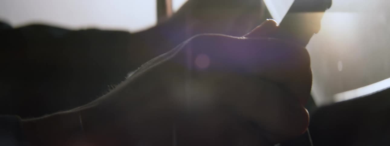Bright sunlight shines through the windshield while a man is driving