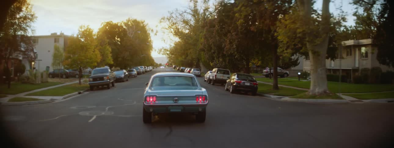 A car riding through a suburb at sunset