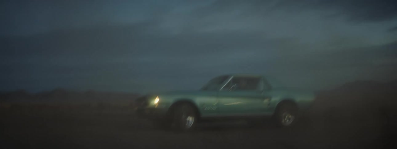 A person is driving a vehicle off road during sunset
