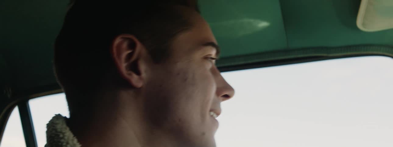 A man laughs while driving