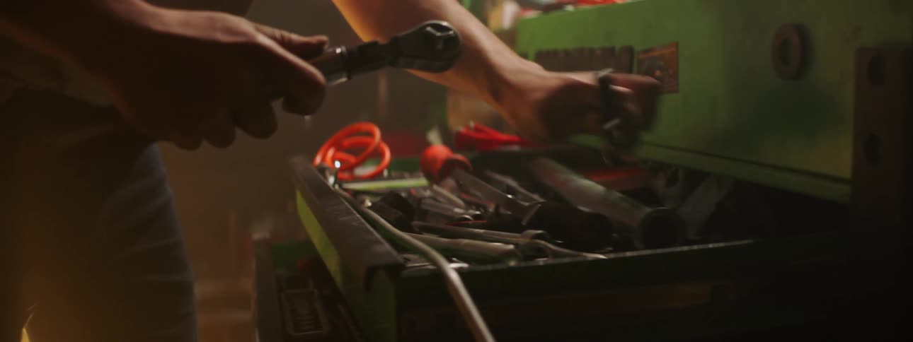 A man digging through a toolbox looking for tools