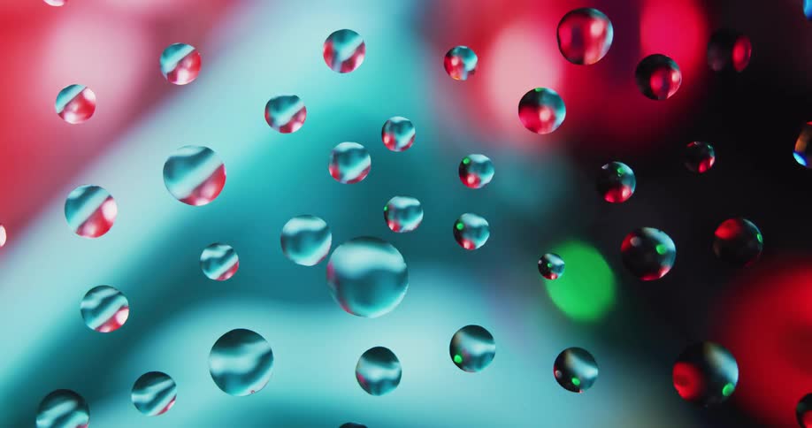A device for creating light effects of used at parties is seen spinning behind a glass panel covered with water beads in the daytime