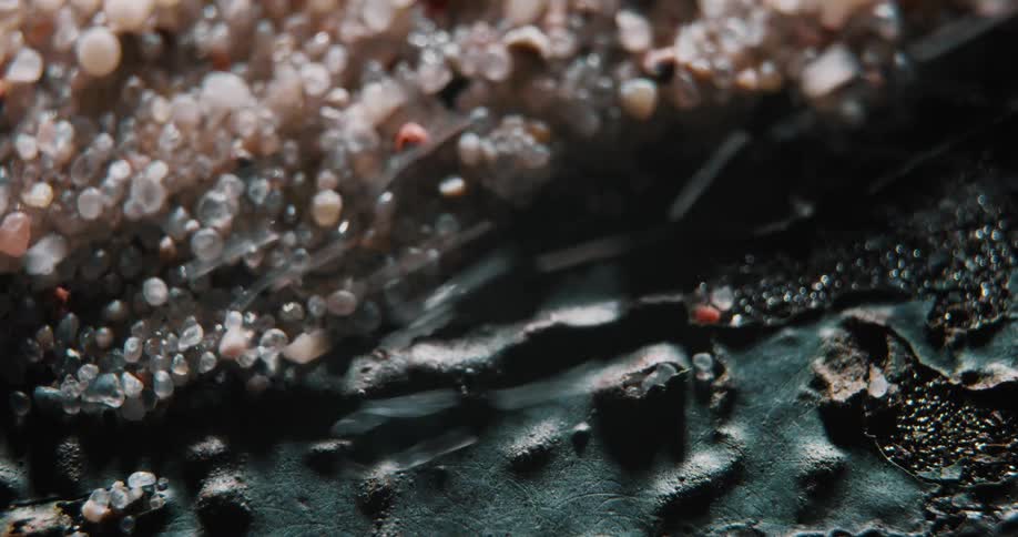 Sand grains are blown off of torn rough surface
