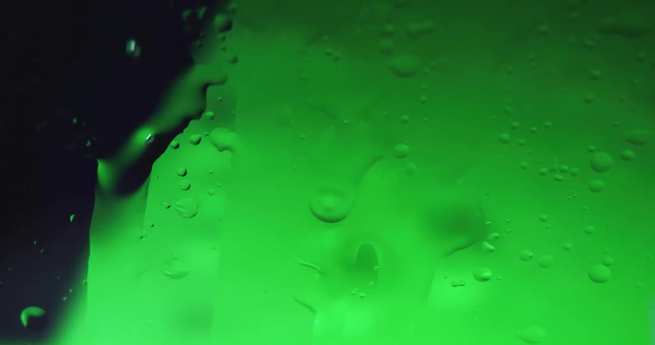 The green liquid moves behind the glass
