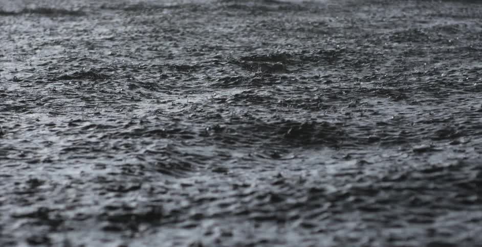 Falling rain creates little splashes among waves
