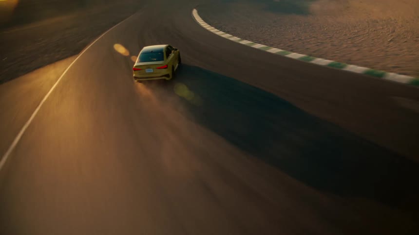 An automobile slides as it speeds around a curve and there are mountains in the distance
