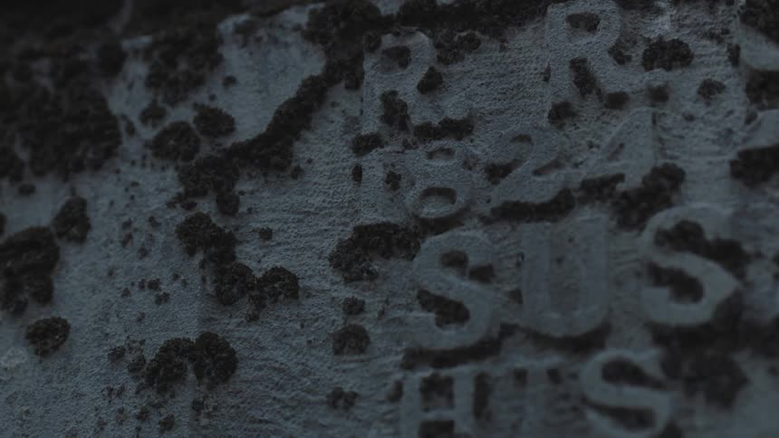 A grave has dates and a name on it