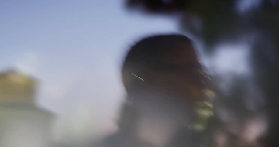 A man walks around in sunglasses in a city at night