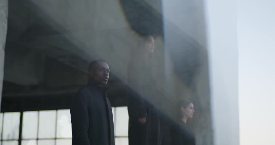 Three models pose together near bare concrete structure